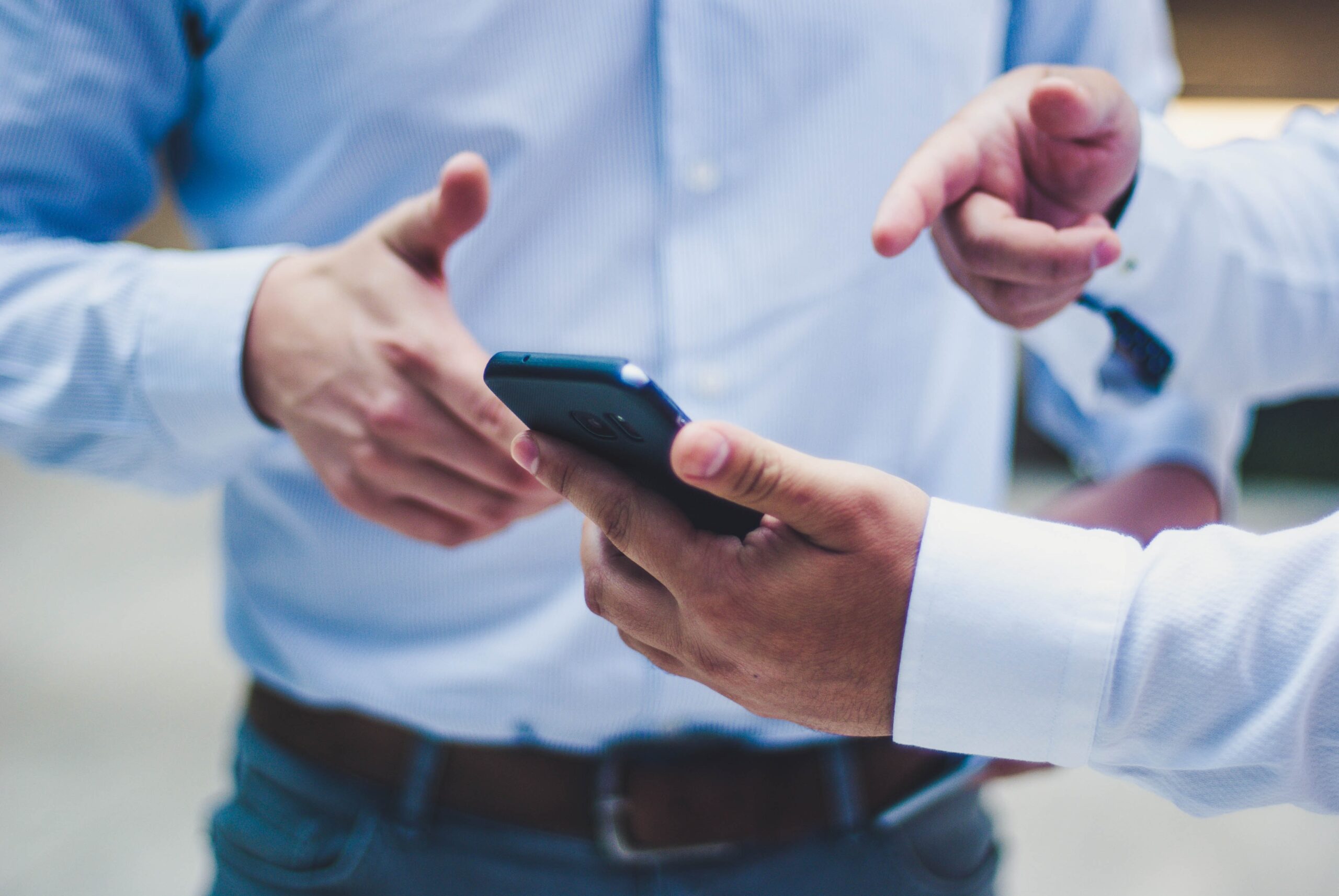 スマホを見ながら会話する男性たち